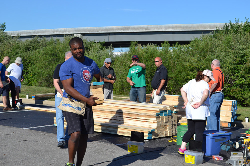 OW employees carrying lumber during Habitat for Humanity Build