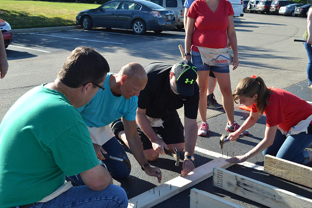 OW employees hammer wood during Habitat for Humanity Build