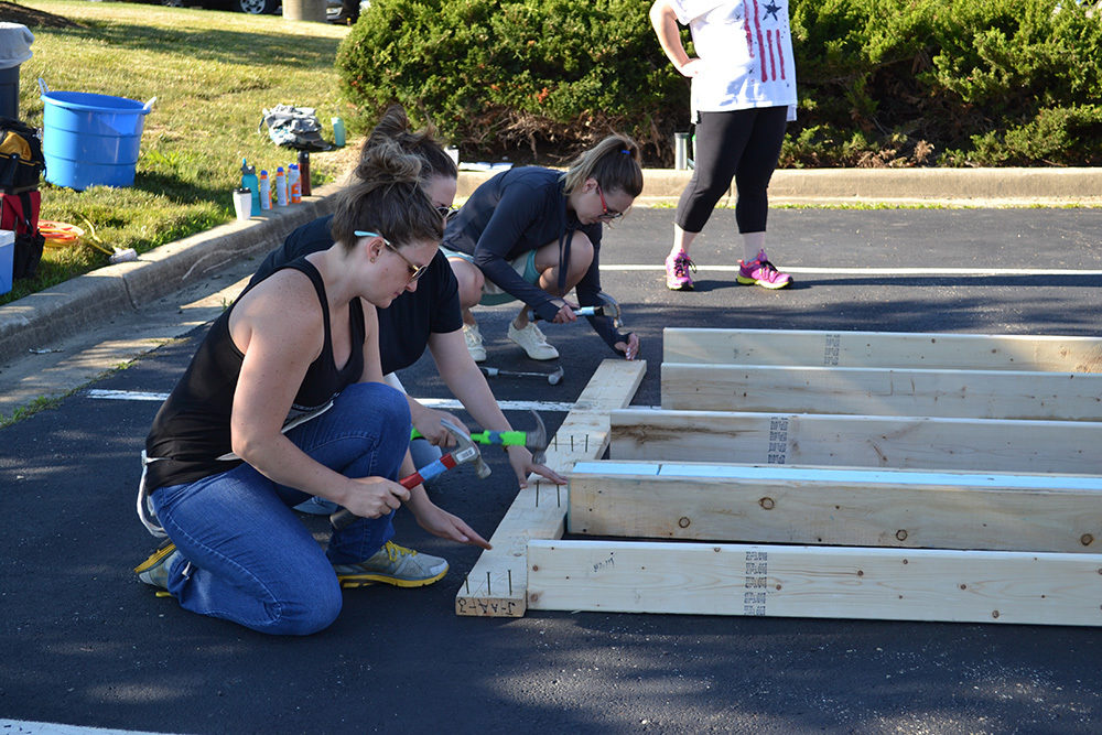 OW employees hammer wood during Habitat for Humanity Build