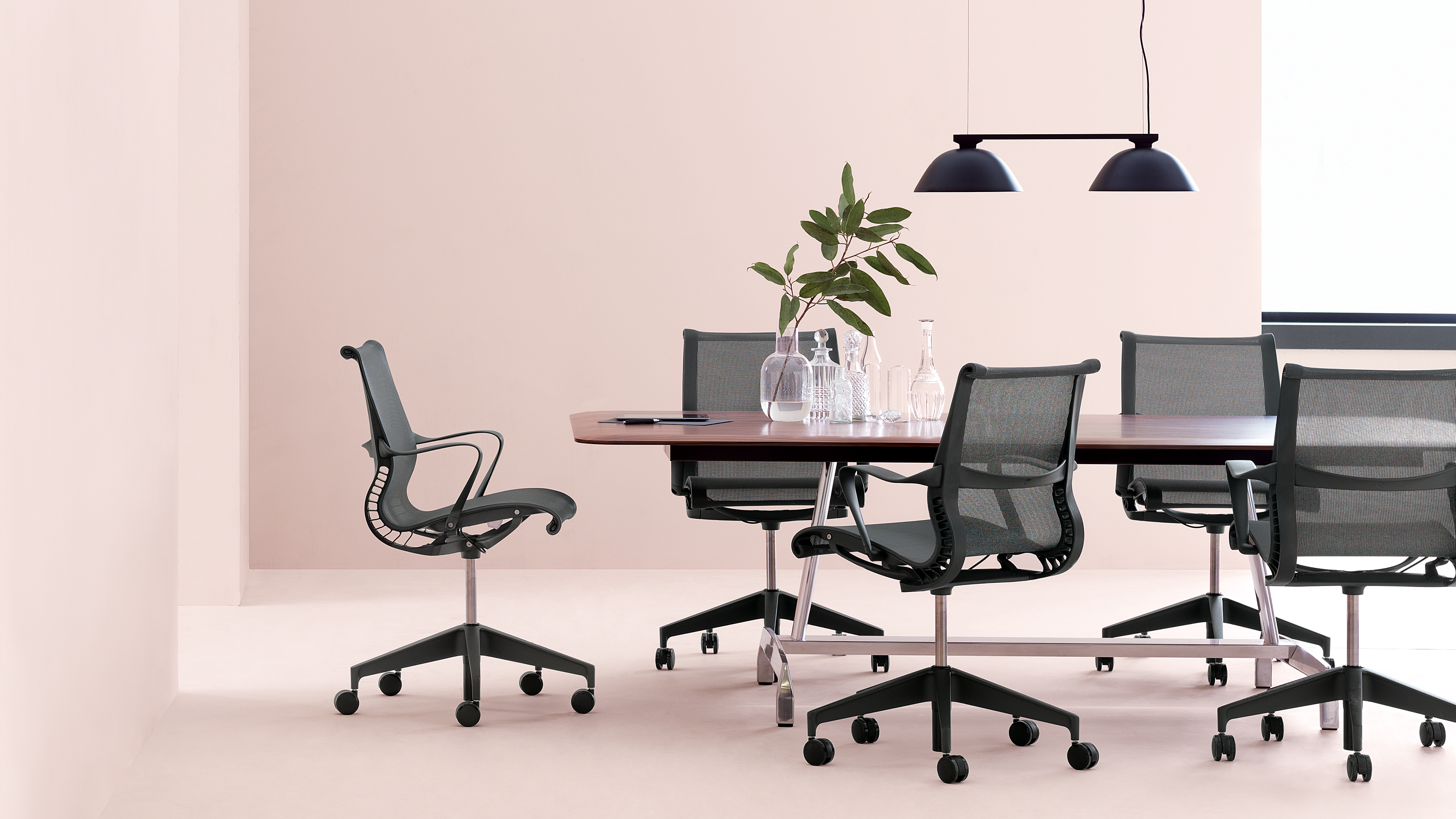 conference room with black chairs and pink walls
