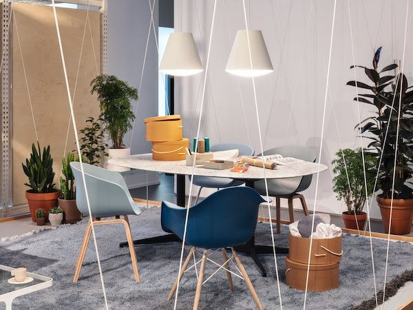 About a Chairs & Eames Molded Plastic Chairs pulled up to white oval Nelson Pedestal Table with white marble top. 2 white sinker pendants hang above table